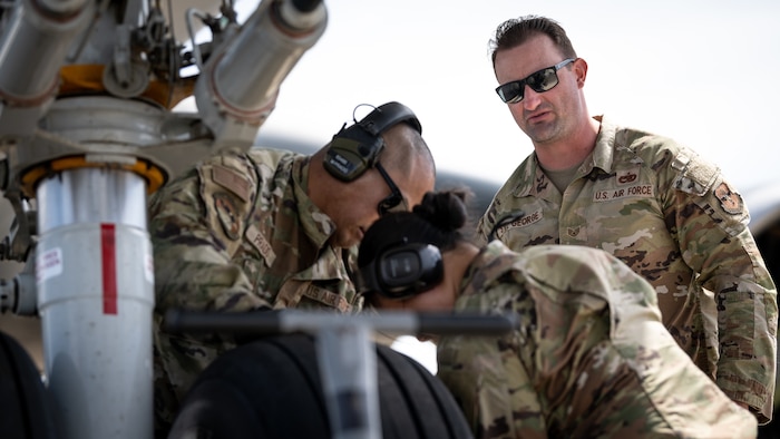 Airmen work on an aircrafts wheel