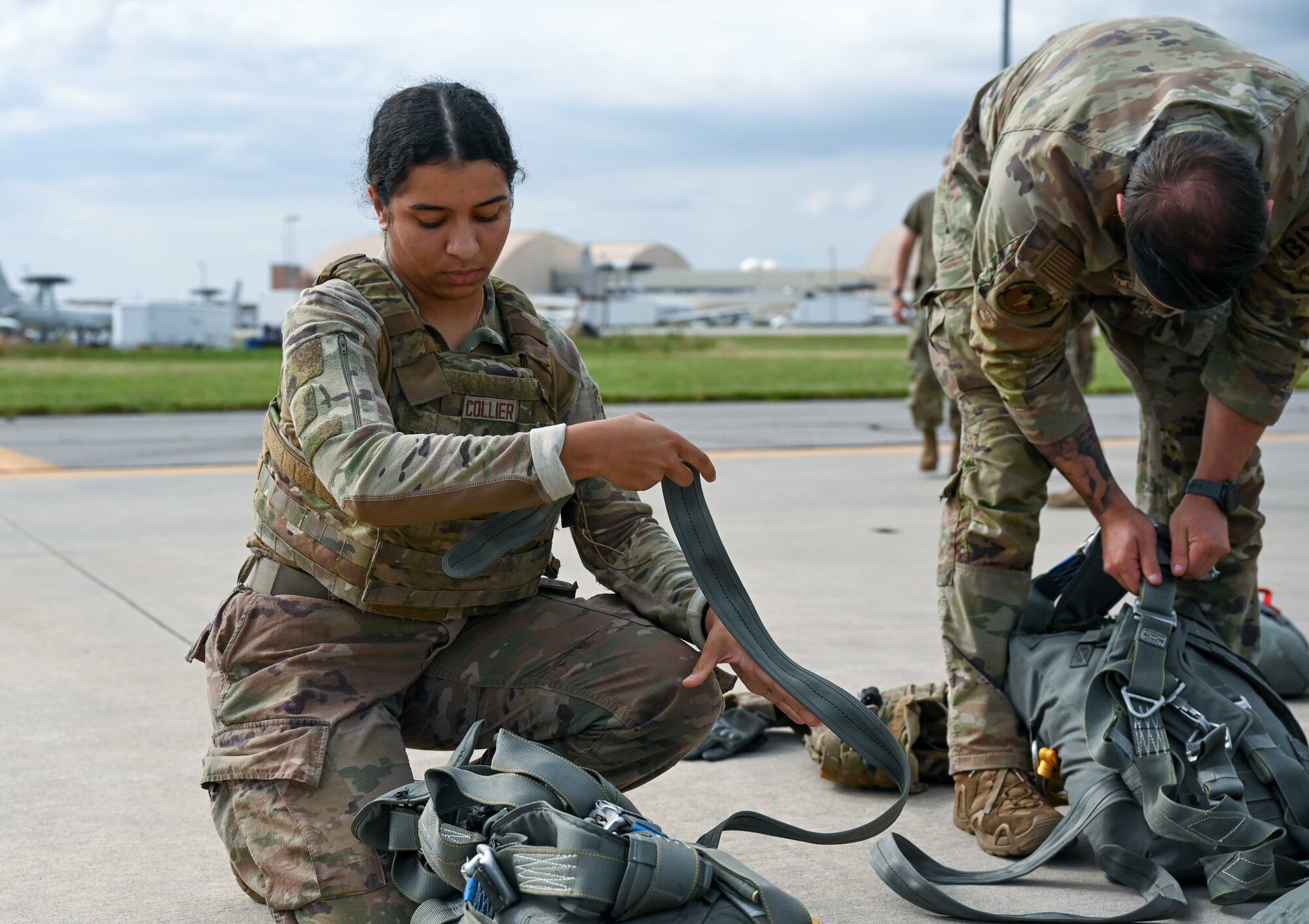 U.S. Air Force Senior Airman Namya Collier, 824th Base Defense Squadron fire team member, and Staff Sgt. Dakota Lesak, 824th BDS jump safety lead, pack gear to prepare for a drop out of a 910th Airlift Wing C-130 Hercules, June 13, 2023, at Tinker Air Force Base, Oklahoma. During Exercise AGILE BLIZZARD-UNIFIED VISION, 824th BDS Airmen exercised securing an airfield, operating in a contingency location, and working with a PUMA-Unmanned Aerial System to connect with high frequency radios. (U.S. Air Force photo by 2nd Lt. Mary Begy)