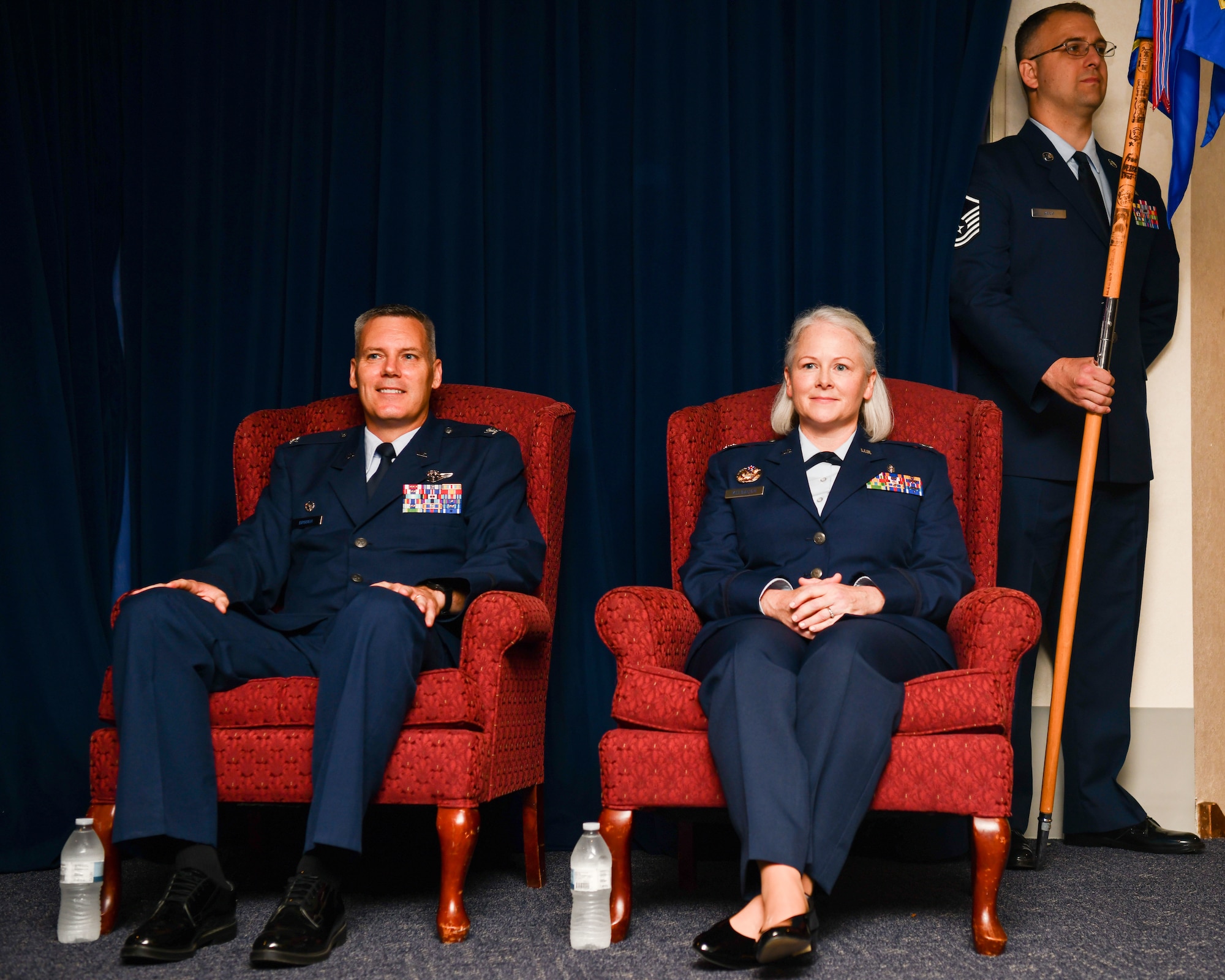 Col. Brad Brough (left), 374th Medical Group commander, and Lt. Col. Jaime F. Kelbaugh, 374th Surgical Operations Squadron commander, listen to remarks from the master of ceremonies during an assumption of command ceremony