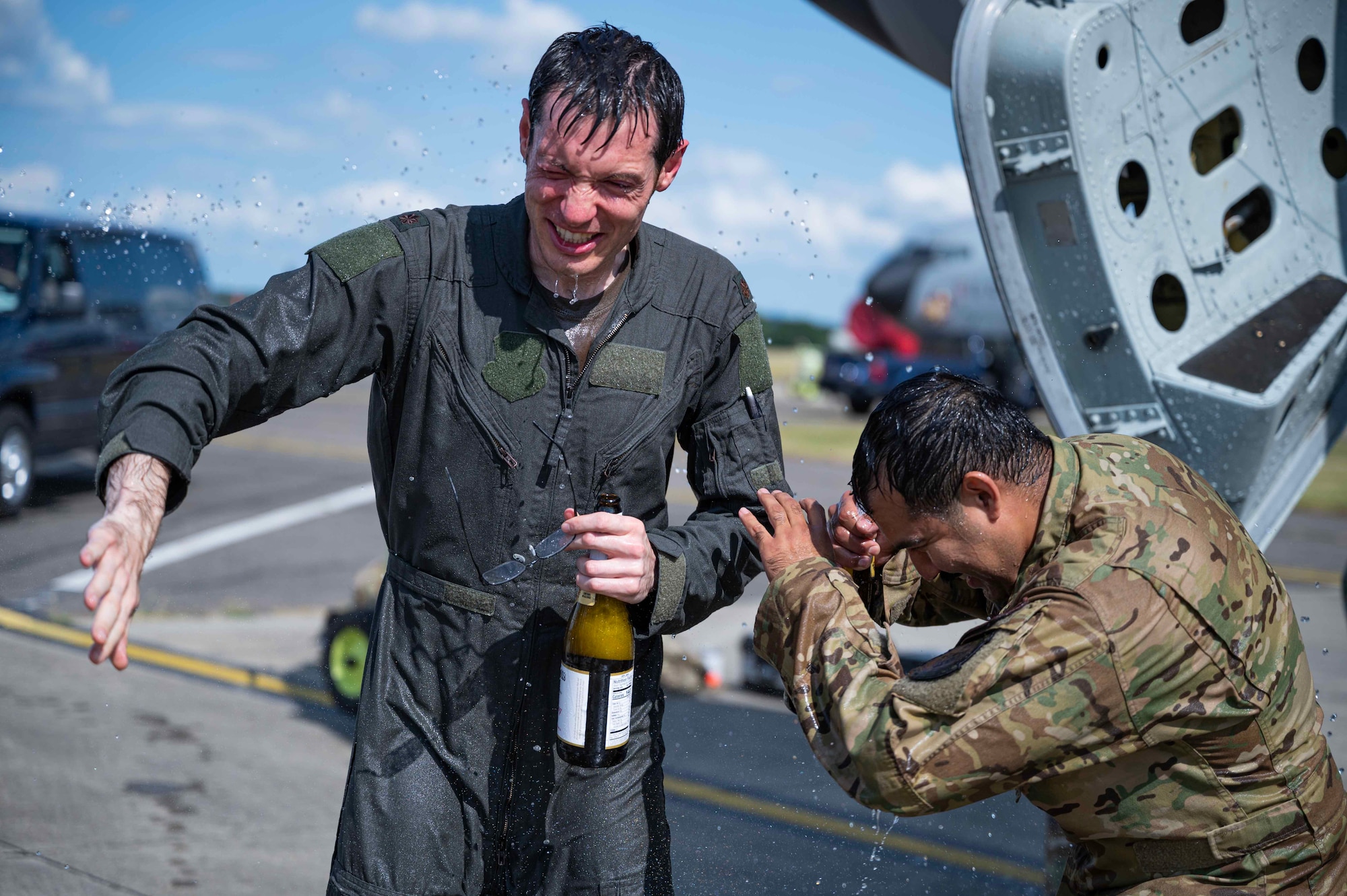 U.S. Air Force Maj. Michael Kamp (left) And Maj. Jonah Guajardo (right), 100th Air Refueling KC-135 Stratotanker Aircraft pilots, celebrate their final, or fini flight at Royal Air Force Mildenhall, England, June 21, 2023. The fini flight, an Air Force tradition celebrating pilots' departure from a unit or the last time they fly an aircraft, is marked by removal of patches and spraying the pilot with water or sparkling cider.  (U.S. Air Force photo by Senior Airman Viviam Chiu)