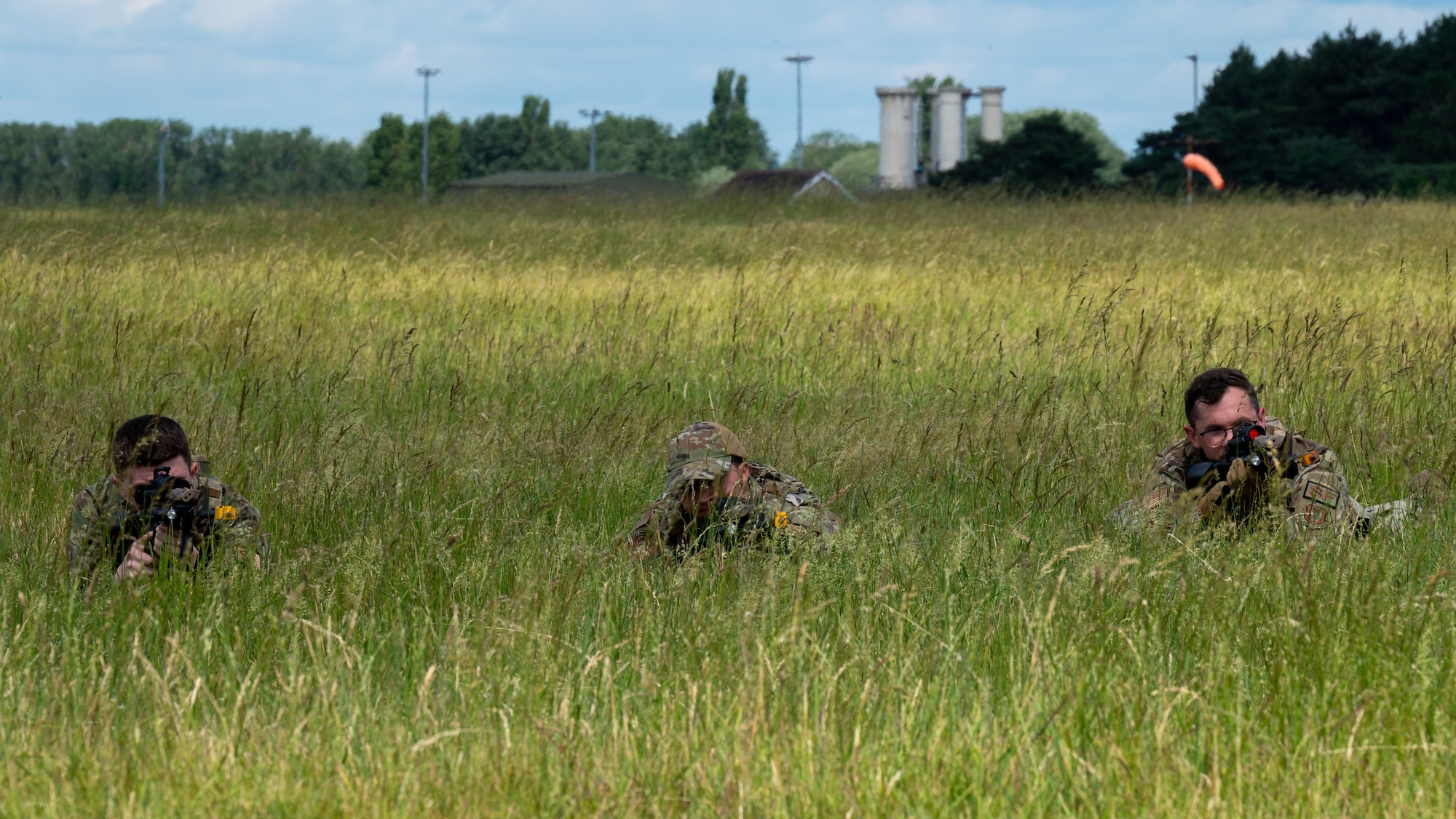 U.S. Air Force Airmen assigned to the 100th Security Forces Squadron, prepare to fire from a concealed position during a training exercise at Royal Air Force Mildenhall, England, June 21, 2023.