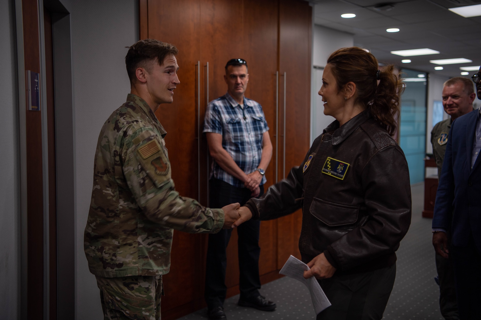 U.S. Air Force Capt. Josiah Fallot 86th Airlift Wing Staff Agency executive officer, left, who hails from Michigan, is coined by Michigan Gov. Gretchen Whitmer, right, at Ramstein Air Base, Germany, June 22, 2023.