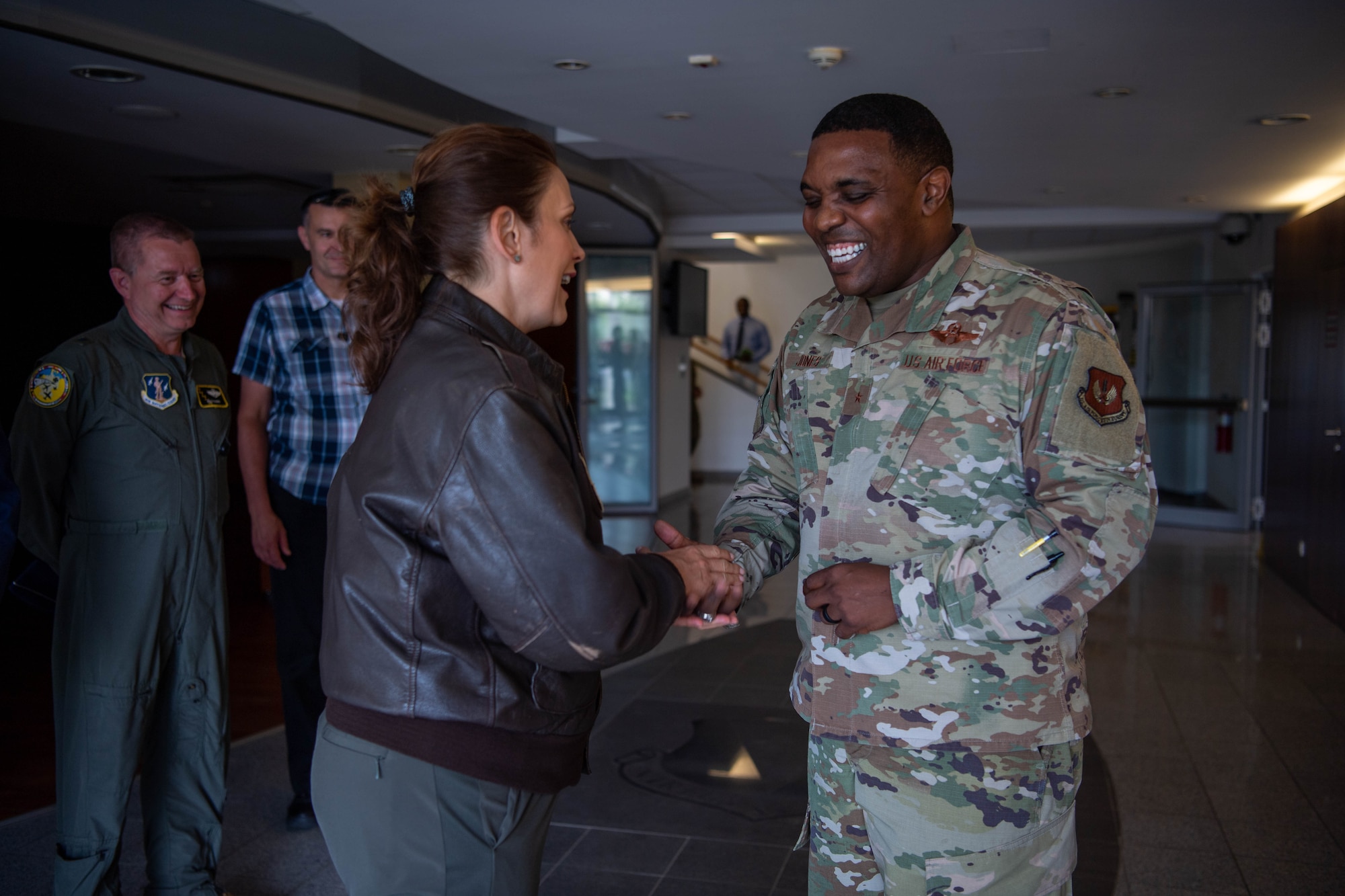 U.S. Air Force Brig. Gen. Ottis C. Jones, 86th Airlift Wing commander, right, and Michigan Gov. Gretchen Whitmer, left, exchange coins during a visit at Ramstein Air Base, Germany, June 22, 2023.