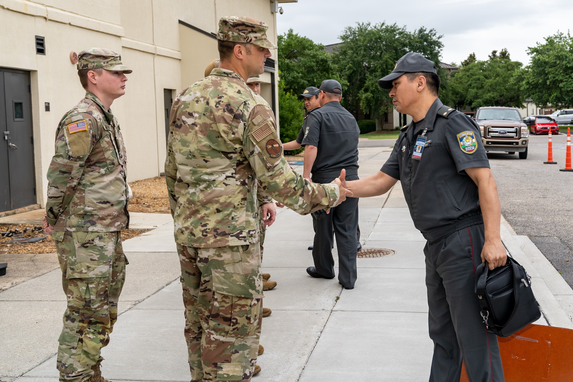 U.S. Air Force Maj. Joseph Smiley, Force Support Training flight commander, greets Senior Officers of the Armed Forces of the Republic of Uzbekistan during a tour of the 335th Training Squadron at Keesler Air Force Base, Mississippi, June 20, 2023.
