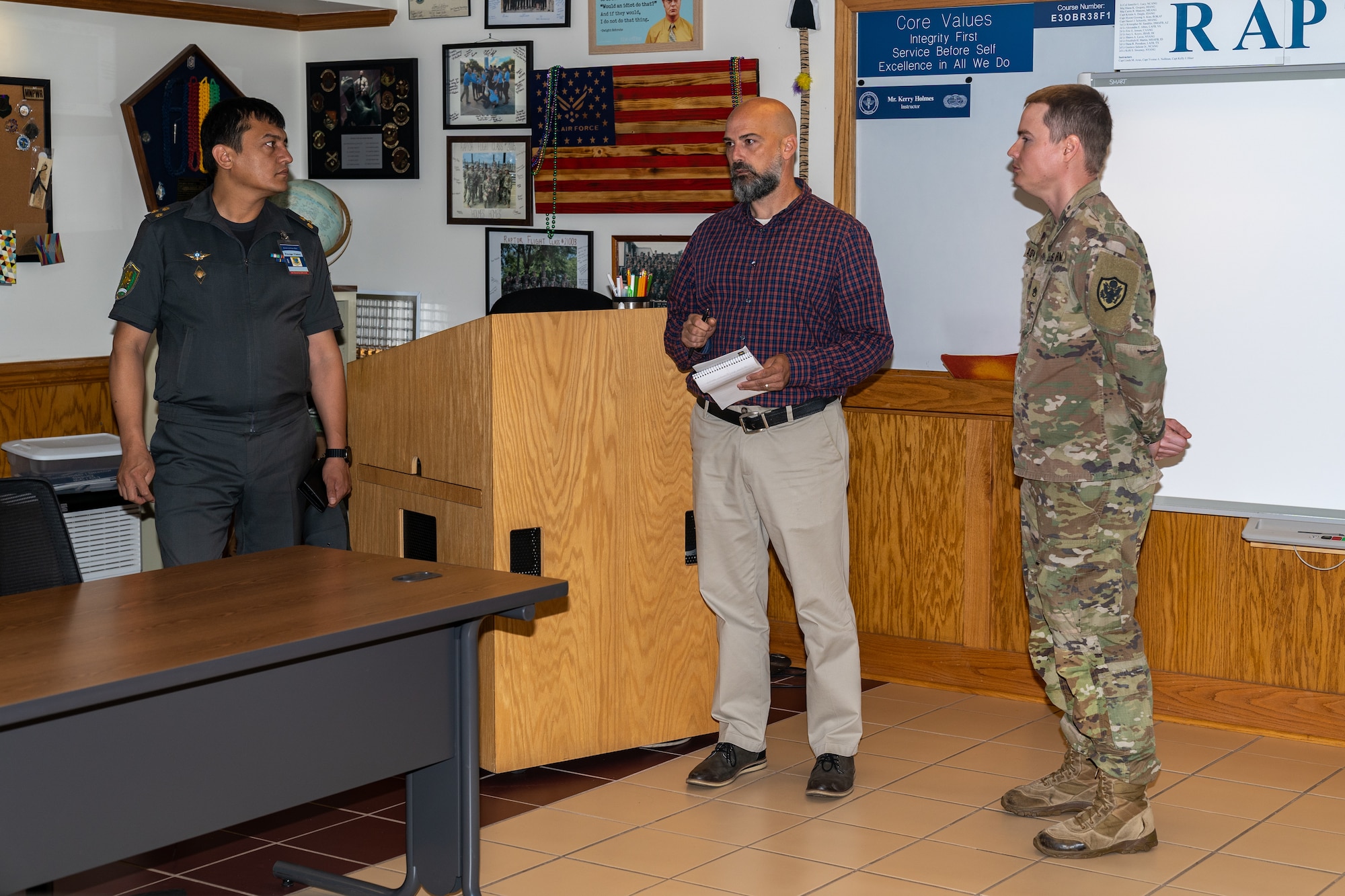 Kerry Holmes, center, Initial Force Support Officer Course instructor, gives an overview of the courses they teach to Senior Officers of the Armed Forces of the Republic of Uzbekistan during a tour of the 335th Training Squadron at Keesler Air Force Base, Mississippi, June 20, 2023.
