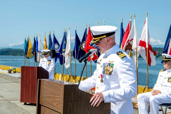 Cmdr. Andrew Crouse, outgoing commanding officer of Naval Magazine (NAVMAG) Indian Island, speaks during a NAVMAG change of command ceremony that took place on the ammunition pier in Port Hadlock, Washington, June 22, 2023. During the ceremony, Cmdr. Andrew Crouse was relieved as commander of NAVMAG Indian Island while Cmdr. Todd Galvin assumed his position as the incoming commanding officer. (U.S. Navy photo by Mass Communication Specialist 2nd Class Gwendelyn L. Ohrazda)