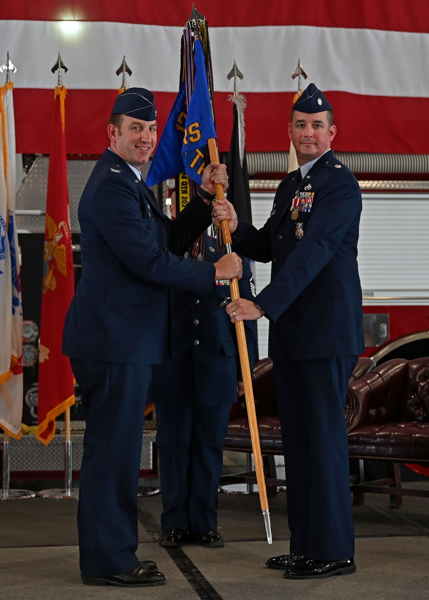 U.S. Air Force Lt. Col. Samuel Logan, outgoing 17th Training Wing commander, passes the guidon to Col. Jason Kulchar, 17th Training Group commander, relinquishing command during the change of command ceremony at the Louis F. Garland Department of Defense Fire Academy, Goodfellow Air Force Base, Texas, June 23, 2023. Passing the guidon represents the transfer of leadership responsibilities to the next commander. (U.S. Air Force photo by Senior Airman Sarah Williams)