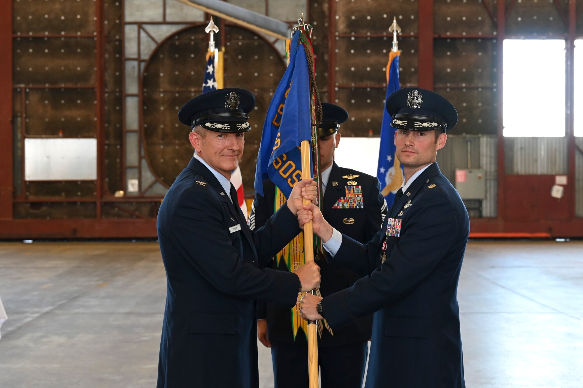A man passes a man a guidon.
