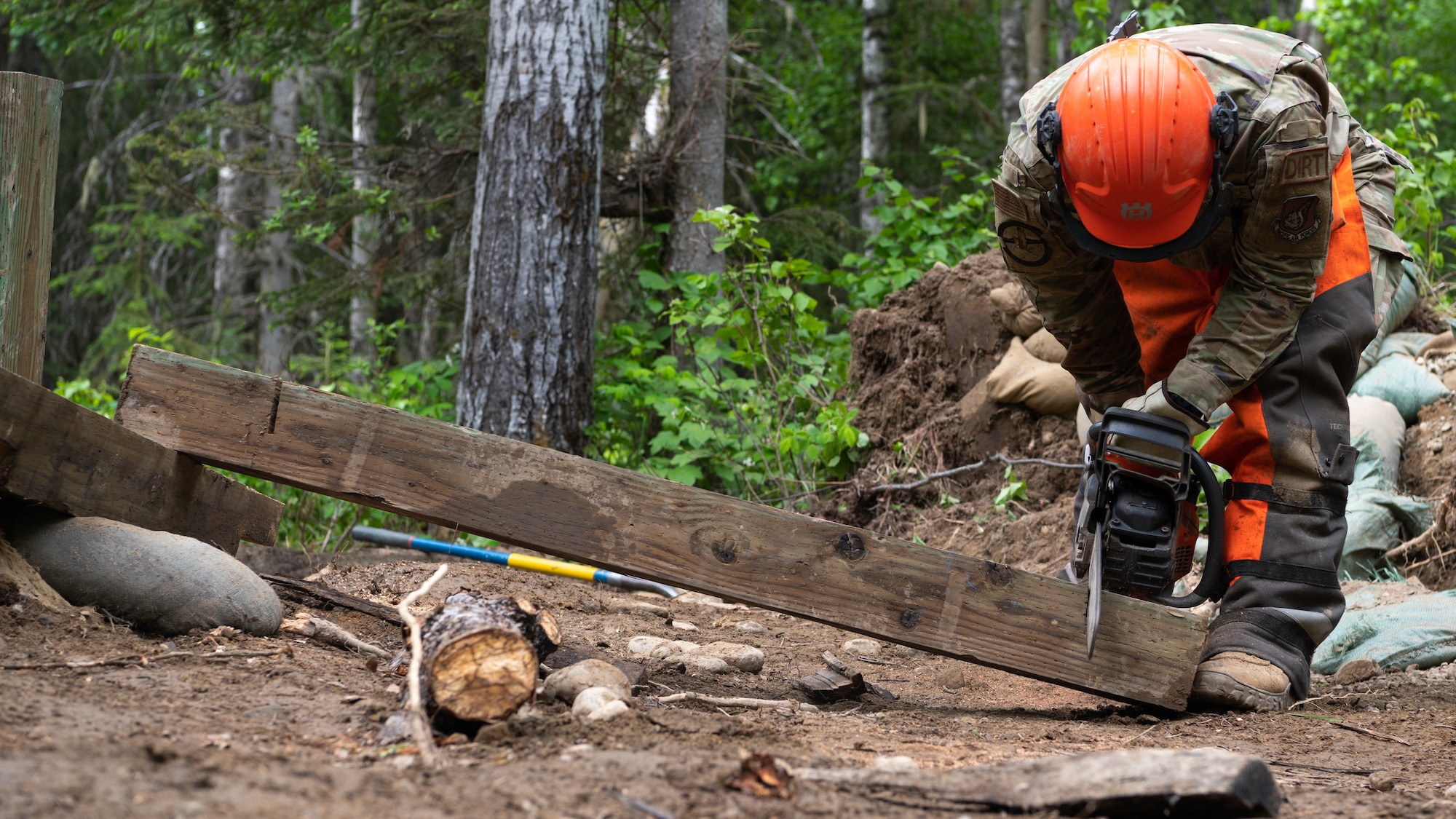 U.S. Air Force Airman 1st Class Joshua McGuire, 773d Civil Engineer Squadron, cuts a beam of wood at Camp Mad Bull at Joint Base Elmendorf-Richardson, Alaska.