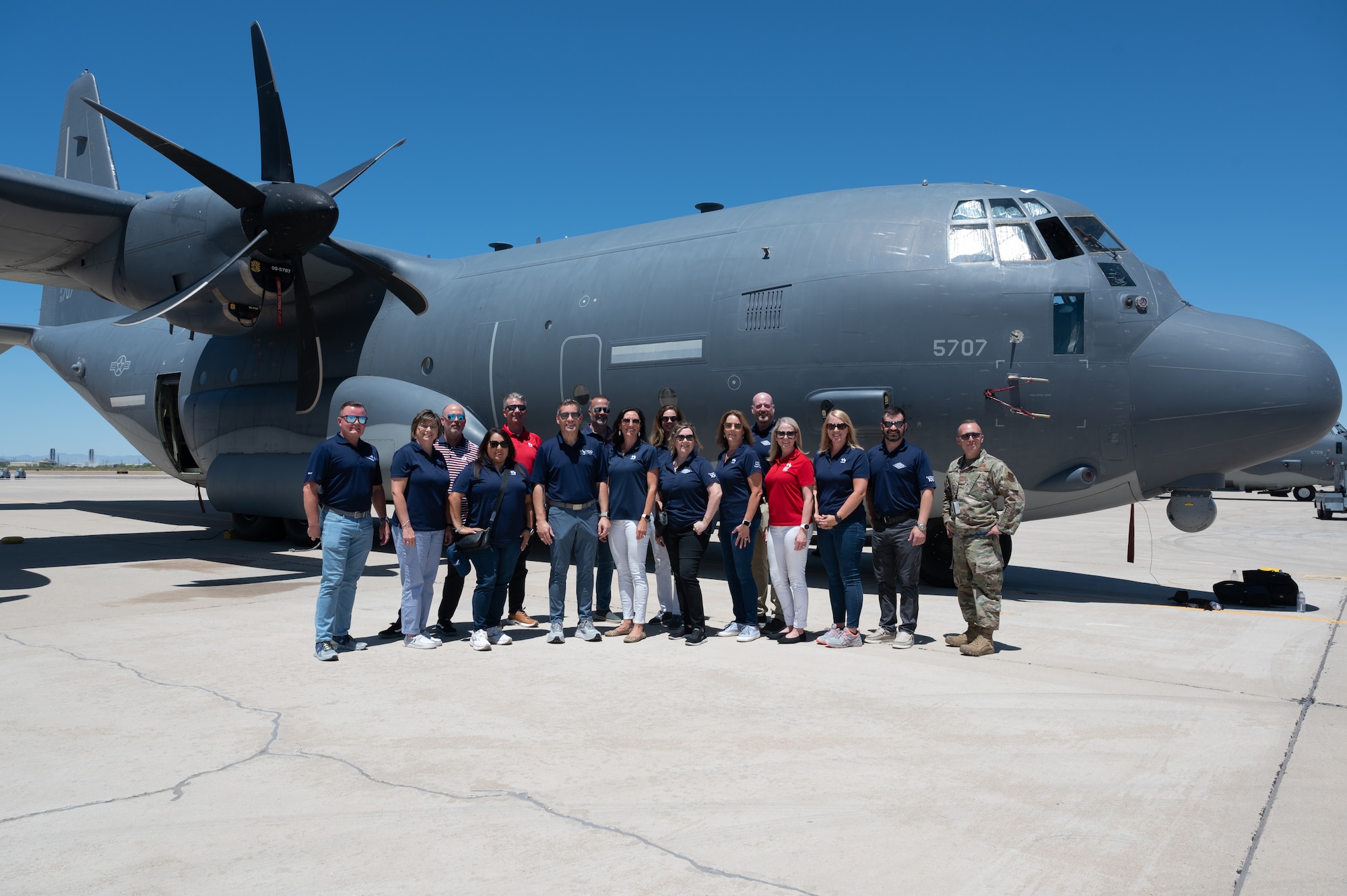USAA senior executives pose for a group photo with U.S. Air Force Tech. Sgt. Eric Doss, 79th Rescue Squadron aerospace maintenance craftsman in front of an HC-130J Combat King II aircraft at Davis-Monthan Air Force Base, Ariz., June 22, 2023.