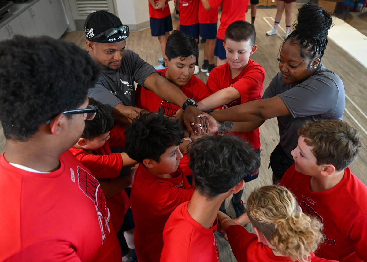A photo of a group of people with their hands interlocked.