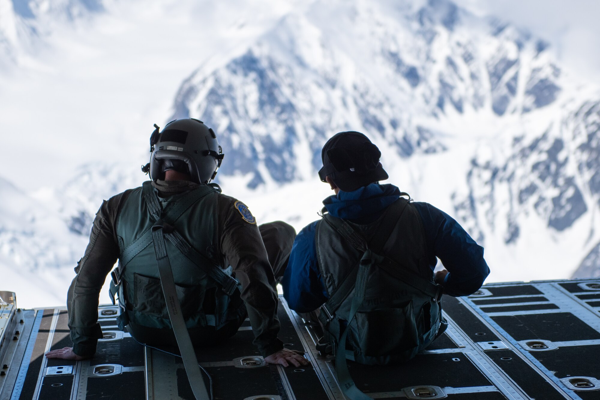 A loadmaster assigned to the 211th Rescue Squadron sits beside an employer of Alaska National Guardsmen on the ramp of a U.S. Air Force HC-130J Combat King II during a Boss Lift flight at Joint Base Elmendorf-Richardson, Alaska.