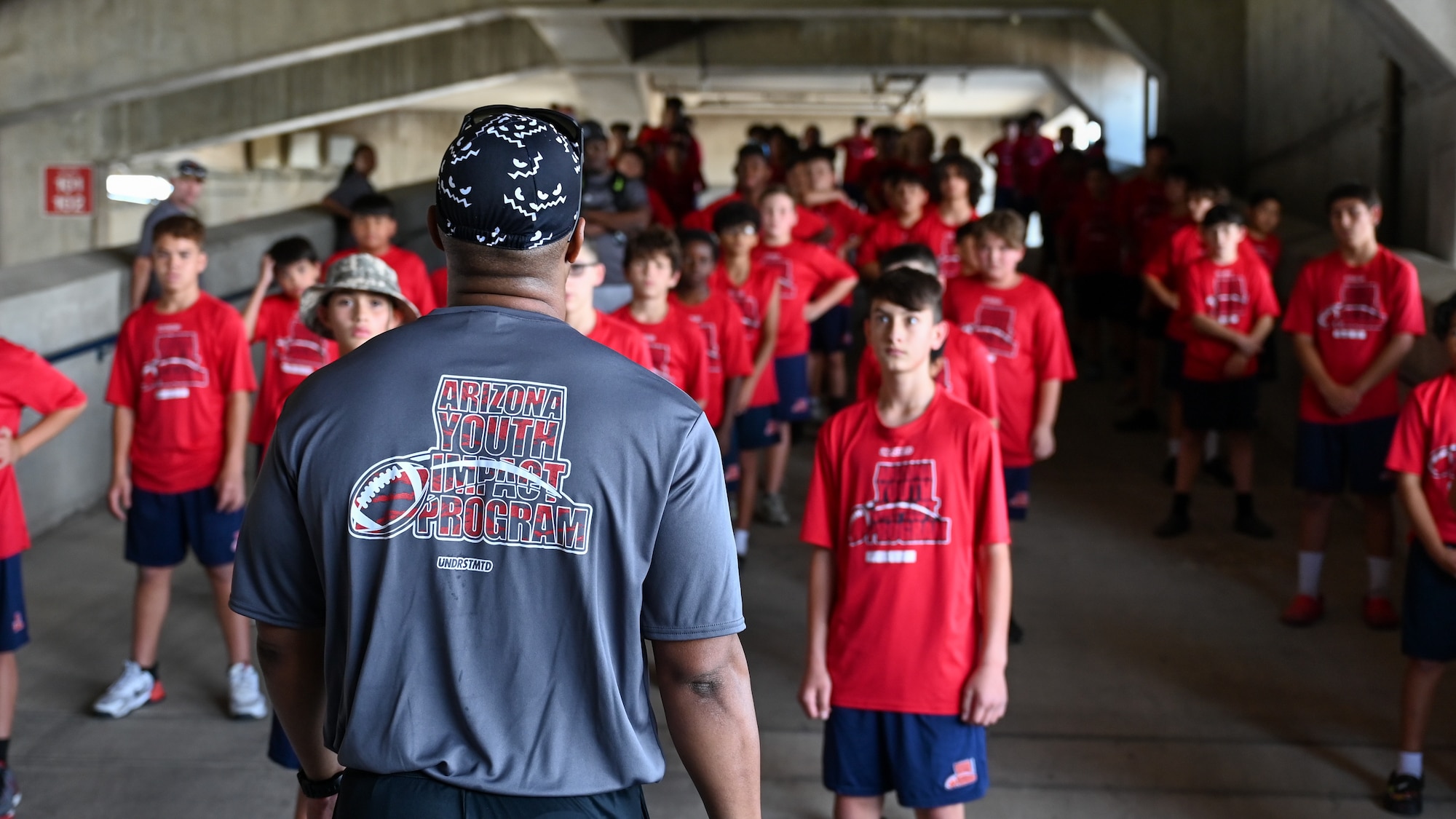 A photo of a man standing in front of a crowd of children.