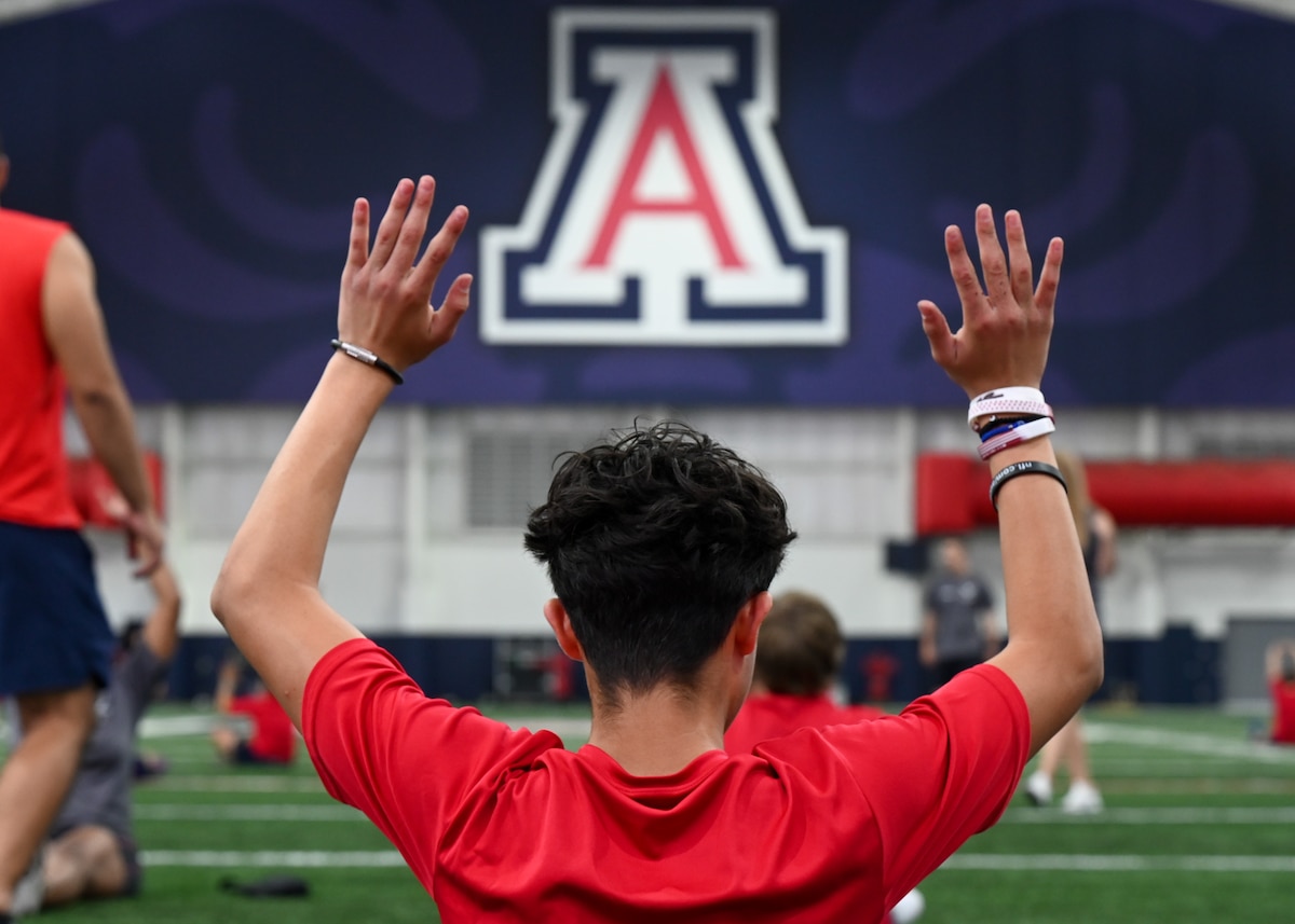 A photo of a boy raising his arms up.
