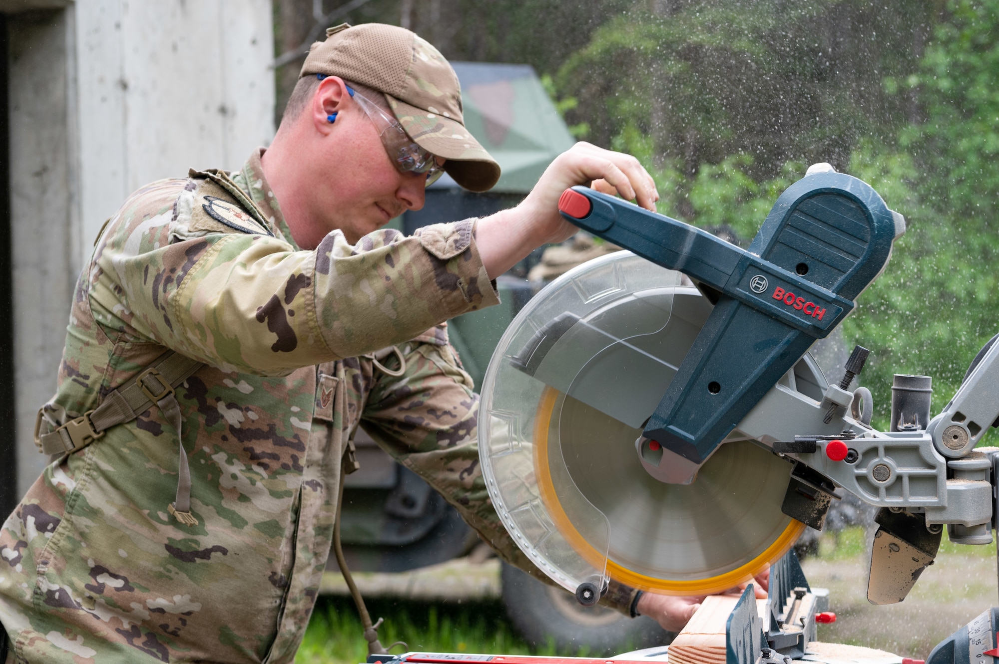 U.S. Air Force Staff Sgt. Daniel Webber, 773d Civil Engineer Squadron, cuts a two-by-four on a glide miter at Camp Mad Bull at Joint Base Elmendorf-Richardson, Alaska.