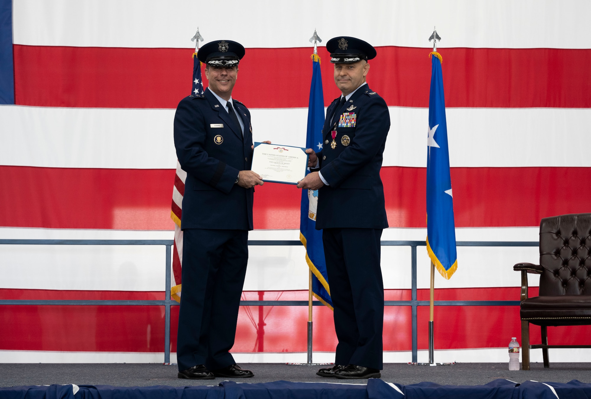 U.S. Air Force Maj. Gen. Andrew J. Gebara, Eighth Air Force and Joint-Global Strike Operations Center commander, left, awards Col. Joseph L. Sheffield, outgoing 28th Bomb Wing commander, the Meritorious Service Medal at Ellsworth Air Force Base, South Dakota, June 23, 2023.