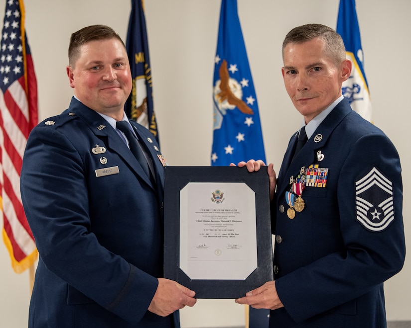Chief Master Sgt. Donald Hartman, right, outgoing senior enlisted leader for the 123rd Force Support Squadron, receives a certificate of retirement from Lt. Col. Kevin Krauss, 123rd Contingency Response Support Squadron commander, during Hartman’s retirement ceremony at the Kentucky Air National Guard Base in Louisville, Ky., May 21, 2023. Hartman is retiring after 23 years of military service. (U.S. Air National Guard photo by Tech. Sgt. Joshua Horton)