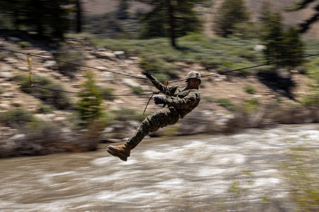 U.S. Marine Corps Lance Cpl. Cody Poafpybitty, an automatic rifleman with Echo Company, 2nd Battalion, 23d Marine Regiment, 4th Marine Division, crosses a gorge using a one-rope bridge during Mountain Training Exercise 4-23 at Marine Corps Mountain Warfare Training Center, Bridgeport, California, June 17, 2023. A one-rope bridge is a complex rope system that is utilized to cross narrow valleys between hills or mountains. Poafpybitty is a native of Pyramid Lake Reservation, NV.