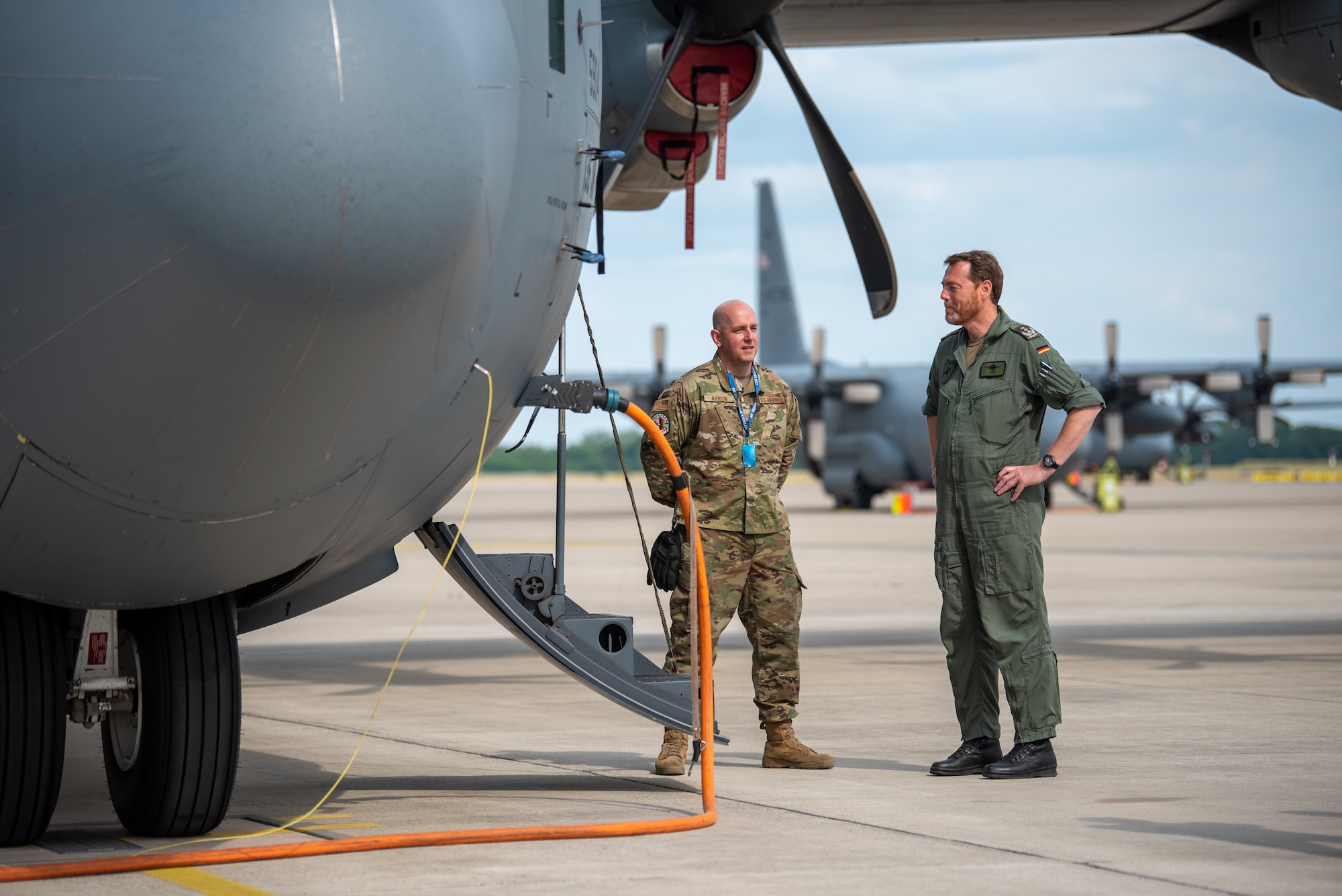 German Col. Christian John, right, commander of the German 62nd Air Transport Wing, speaks with U.S. Air Force Tech. Sgt. Johnny Arrow, a hydraulics technician assigned to the 136th Airlift Wing, Texas National Guard, during exercise Air Defender 2023 (AD23) at Wunstorf Air Base, Germany, June 15, 2023. Exercise AD23 integrates both U.S. and allied air-power to defend shared values, while leveraging and strengthening vital partnerships to deter aggression around the world. (U.S. Air National Guard photo by Master Sgt. Phil Speck)