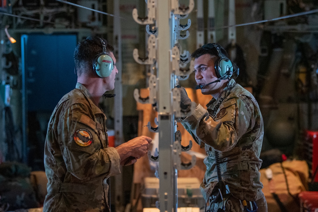 Senior Airman Tyler Phillips (right), talks to Master Sgt. Chris Kinsberger, both loadmasters assigned to the Kentucky Air National Guard’s 165th Airlift Squadron, aboard a 123rd Airlift Wing C-130J Super Hercules during exercise Air Defender 2023 in Saarbrucken, Germany, June 15, 2023. AD23 integrates both U.S. and allied air-power to defend shared values, while leveraging and strengthening vital partnerships to deter aggression around the world. (U.S. Air National Guard photo by Master Sgt. Phil Speck)