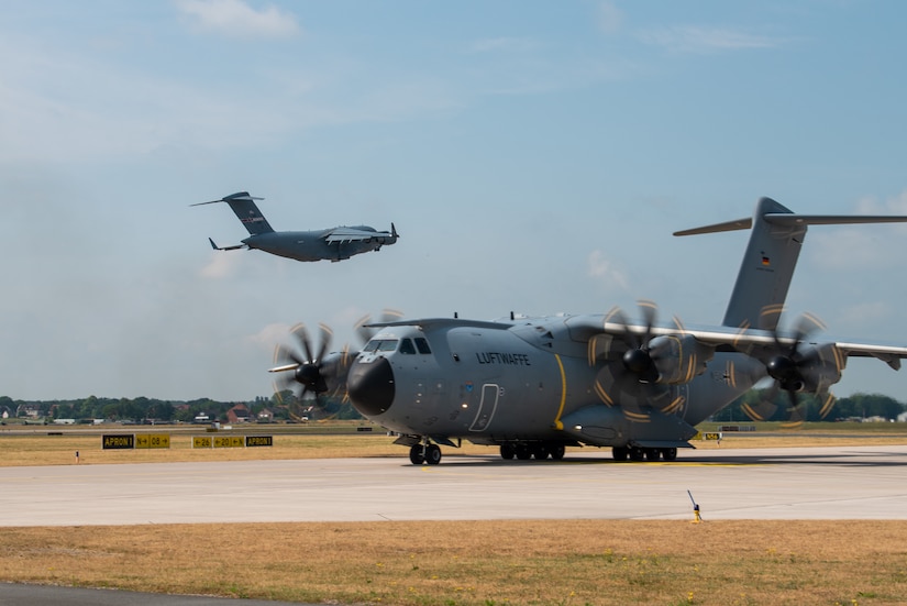 A German A400 Atlas taxis as a U.S. Air Force C-17 Globemaster aircraft assigned to the 164th Airlift Wing, Tennessee National Guard, takes off at Wunstorf Air Base during exercise Air Defender 2023 (AD23) in Wunstorf, Germany, June 21, 2023. Exercise AD23 integrates both U.S. and allied air-power to defend shared values, while leveraging and strengthening vital partnerships to deter aggression around the world. (U.S. Air National Guard photo by Master Sgt. Phil Speck)