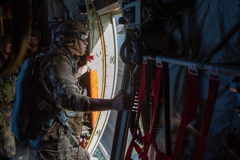 Tech. Sgt. Brian Meledrez, a tactical air control party Airman from the 14th Air Support Operations Squadron, looks out a paratroop door of a Kentucky Air National Guard C-130J Super Hercules during exercise Air Defender 2023 in Saarbrucken, Germany, June 15, 2023. AD23 integrates both U.S. and allied air-power to defend shared values, while leveraging and strengthening vital partnerships to deter aggression around the world. (U.S. Air National Guard photo by Master Sgt. Phil Speck)