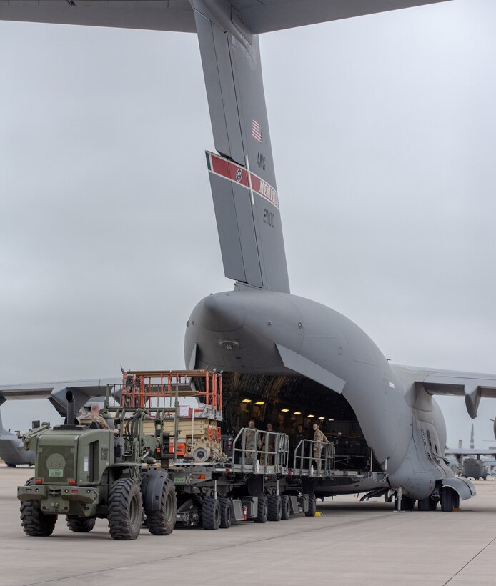 U.S. Airmen with the 123rd Contingency Response Element, 123rd Airlift Wing, Kentucky National Guard, unload cargo from a U.S. Air Force C-17 Globemaster III aircraft assigned to the 164th Airlift Wing, Tennessee National Guard, in preparation for exercise Air Defender 2023 (AD23) at Wunstorf Air Base, Germany, June 4, 2023. Exercise AD23 integrates both U.S and allied air-power to defend shared values, while leveraging and strengthening vital partnerships to deter aggression around the world. (U.S. Air National Guard photo by Senior Master Sgt. Vicky Spesard)