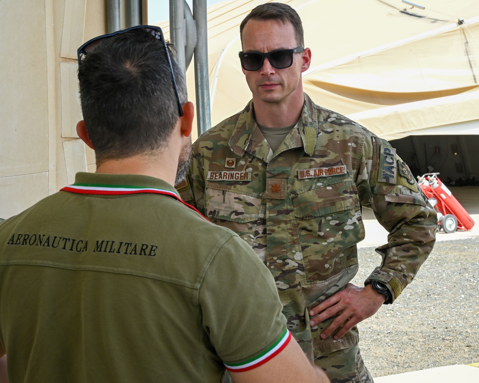 U.S. Air Force Maj. Shawn Bearinger, 82nd Expeditionary Air Support Operations Squadron, speaks with Italian Air Force Maj. Antonio D’Oria, force protection unit commander, during a tour of an Italian Air Force Eurofighter Typhoon at Ali Al Salem Air Base, Kuwait, June 22, 2023. The visit set the stage for cooperation between the 82nd EASOS and the ITAF. Collaborations like these happen everyday and they help secure our position as CENTCOM’s premier coalition combat enabler. (U.S. Air Force photo by Staff Sgt. Breanna Diaz)