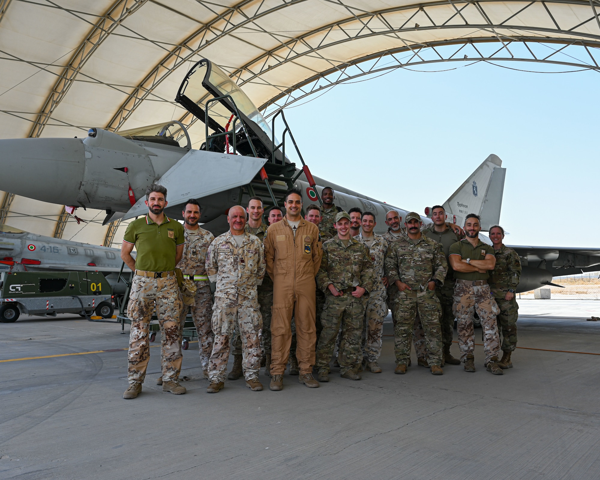 Service members of the U.S. Air Force, the U.S. Army and the Italian Air Force stand together in front of an Italian Eurofighter Typhoon after a tour of the aircraft at Ali Al Salem Air Base, Kuwait, June 22, 2023. Sharing our knowledge and capabilities with one another is critical to increasing the interoperability of our forces, and projecting decisive coalition combat power. (U.S. Air Force photo by Staff Sgt. Breanna Diaz)