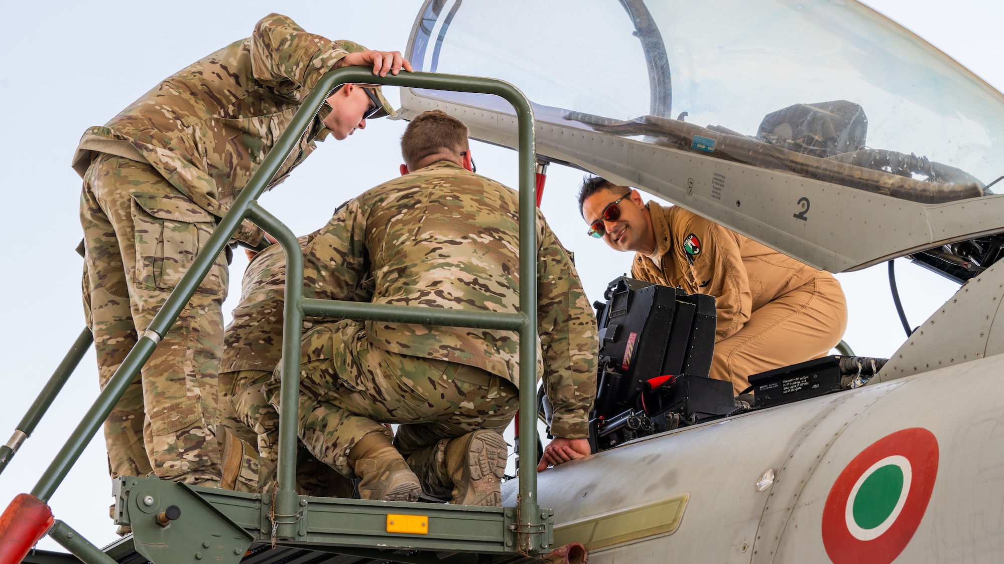 Italian Air Force Maj. Maurizio Lanzilotto (right), talks to Tactical Air Control Party (TACP) Airmen from the 82nd Expeditionary Air Support Squadron about the controls within the cockpit of an Italian Eurofighter Typhoon at Ali Al Salem Air Base, Kuwait, June 22, 2023. The visit set the stage for cooperation between the 82nd EASOS and the ITAF. Collaborations like these happen everyday and they help secure our position as CENTCOM’s premier coalition combat enabler. (U.S. Air Force photo by Staff Sgt. Kevin Long)