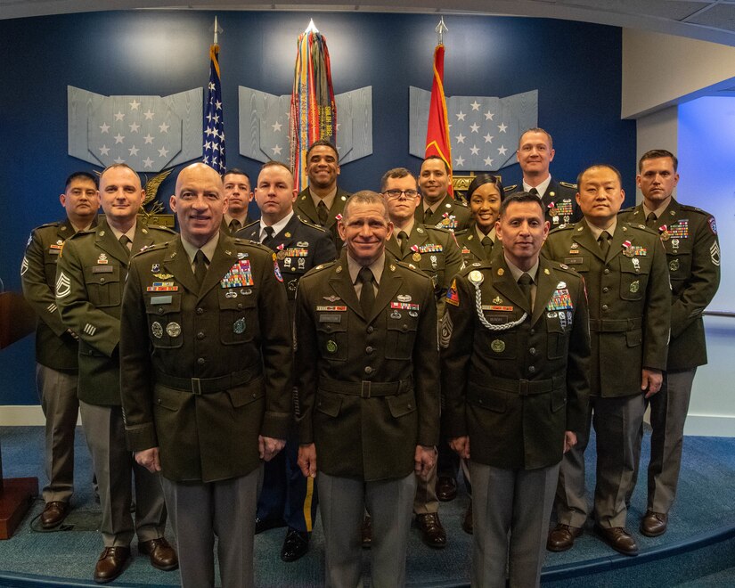 Group of people in U.S. Army uniform pose for photo.