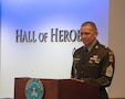 Man in U.S. Army uniform stands at podium to speak.