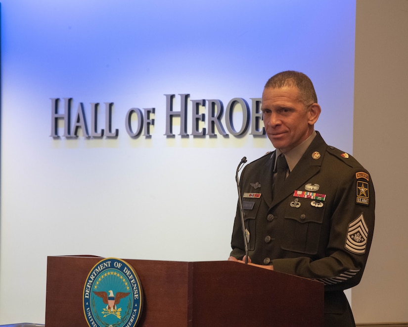 Man in U.S. Army uniform stands at podium to speak.