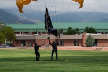 Member of Golden Knights Parachute team lands with Army flag.