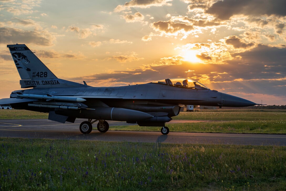 A plane lands at twilight  during a training exercise.