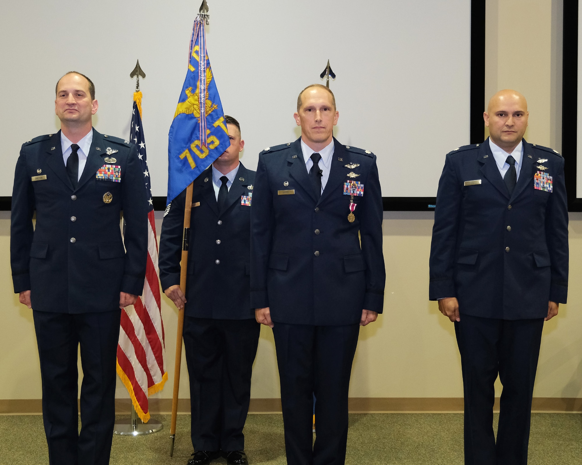 photo of four uniformed, US military members standing at attention on a stage