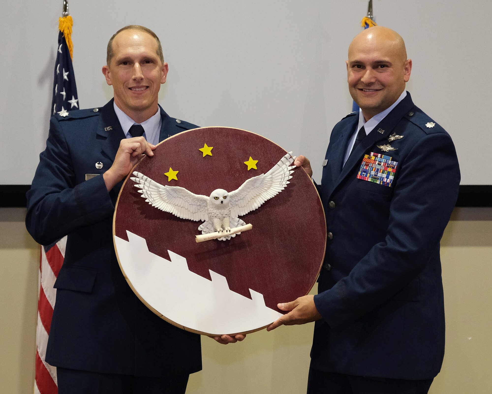 photo of two uniformed, US military members holding a plaque