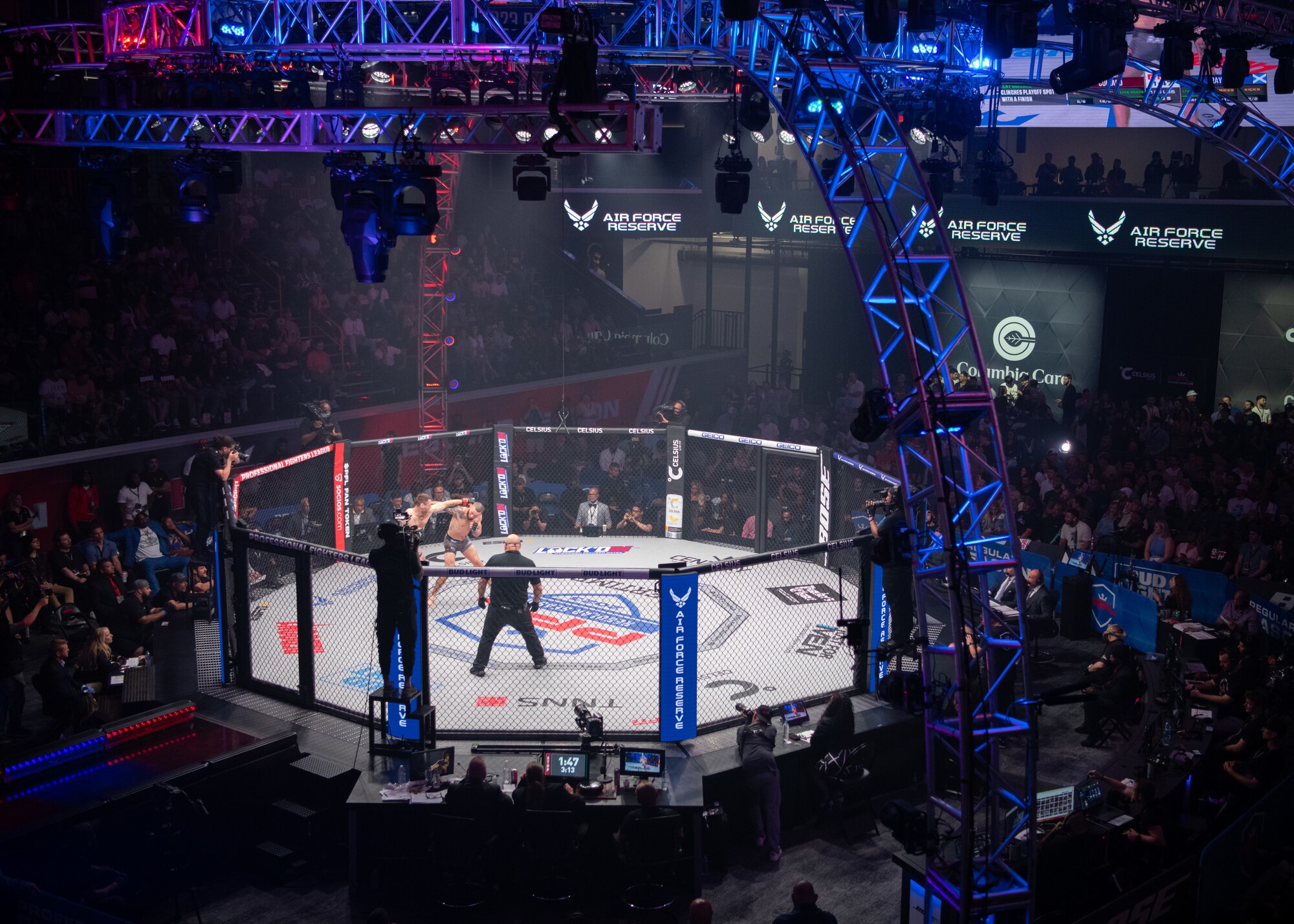 Two fighters engage in competition inside a cage.