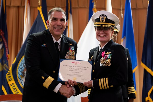 Rear Adm. Matthew Case, commander, Naval Medical Forces Atlantic, and chief of the Medical Service Corps, presents an award to Capt. Melissa C. Austin during a change of command ceremony for Navy Medicine Readiness and Training Command (NMRTC) Fort Belvoir at the Woodlawn Chapel onboard Fort Belvoir June 23.