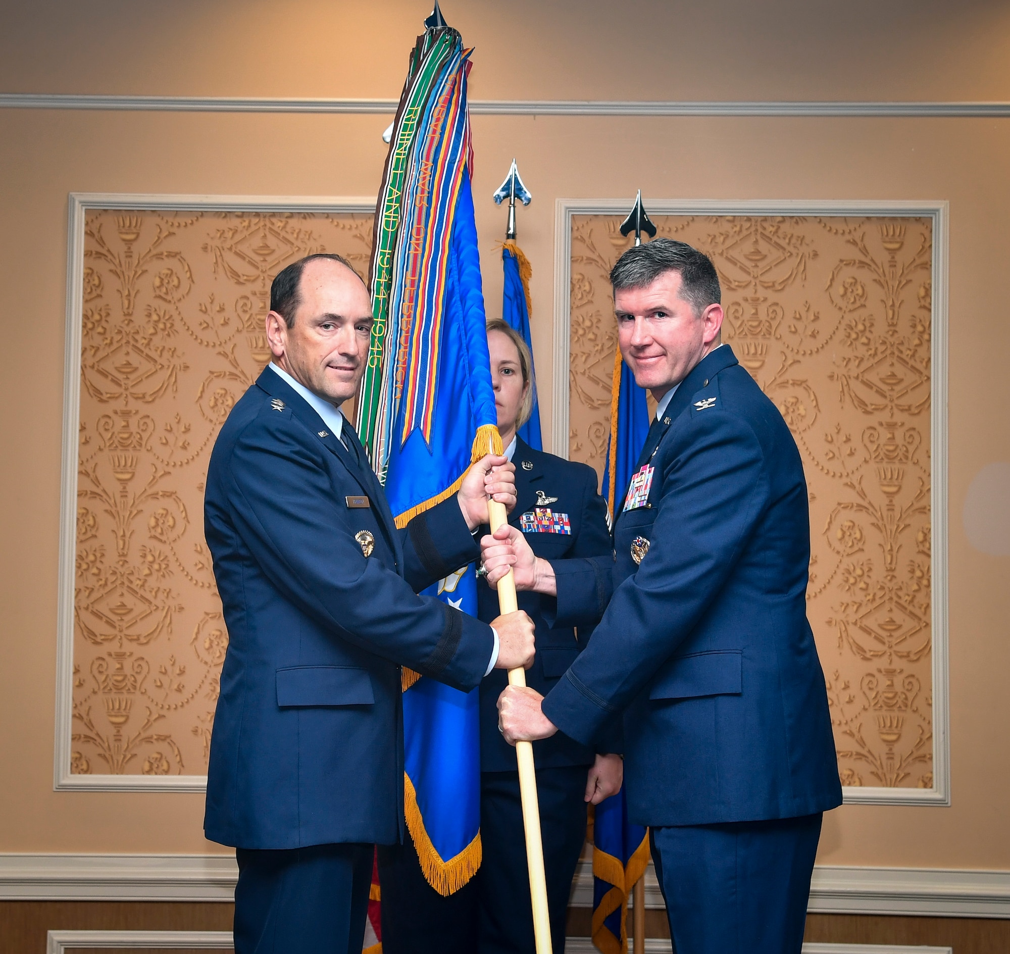 Two individuals hold an Air Force Wing guidon.