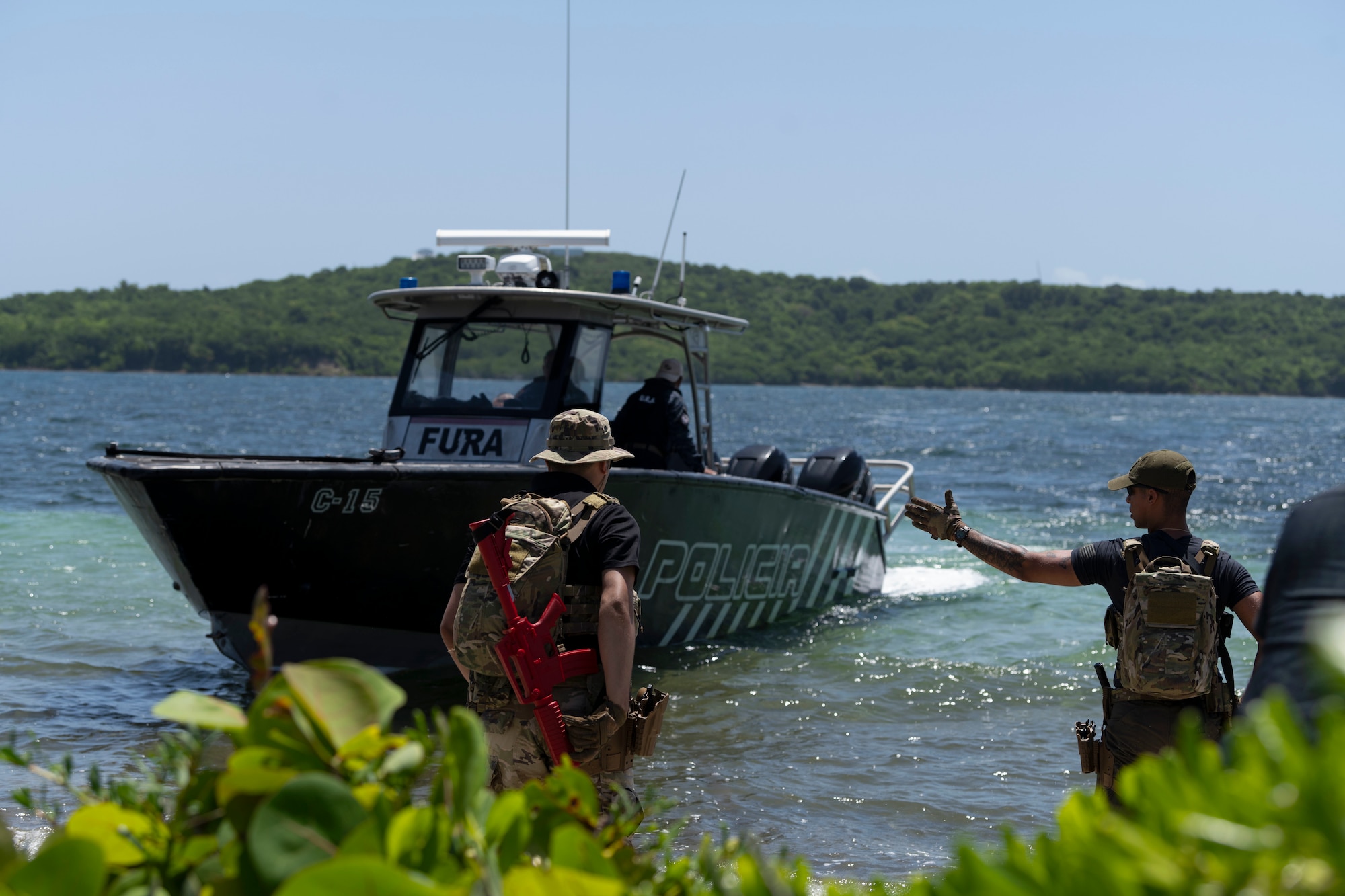 U.S. Airmen assigned to the 156th Security Operations Squadron, approach a boat assigned to the Puerto Rico Police Department, Unidad Marítima, Fuerzas Unidas de Rápida Acción, during the Advisor Edge exercise at Roosevelt Roads, Ceiba, Puerto Rico, June 8, 2023. Advisor Edge was a multi-unit exercise with the integration of government agencies, where participant units tested air advising skills and strengthened partnerships through unique challenges, allowing burden sharing in combat with partner nations. (U.S. Air National Guard photo by Master Sgt. Rafael D. Rosa)