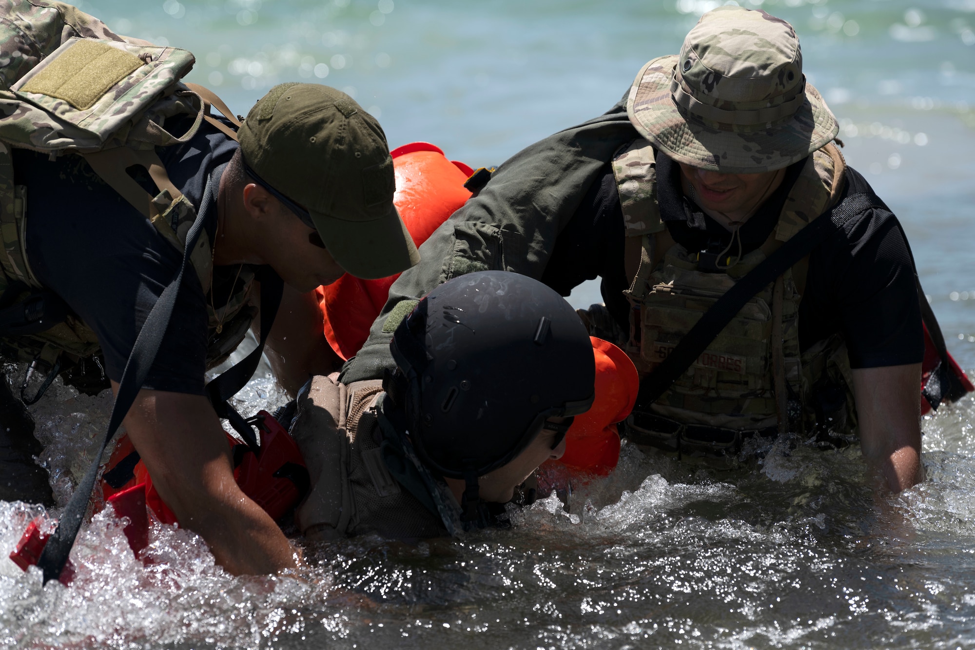 U.S. Air Force Senior Airman Jean Diaz, a security forces journeyman, left, and Senior Airman Julio Soto, a security forces journeyman, right, both assigned to the 156th Security Operations Squadron, carry Senior Airman Ben Leveillee, a survival, evasion, resistance and escape specialist to the 60th Operations Support Squadron, out of the water during the Advisor Edge exercise at Roosevelt Roads, Ceiba, Puerto Rico, June 8, 2023. Advisor Edge was a multi-unit exercise with the integration of government agencies, where participant units tested air advising skills and strengthened partnerships through unique challenges, allowing burden sharing in combat with partner nations. (U.S. Air National Guard photo by Master Sgt. Rafael D. Rosa)