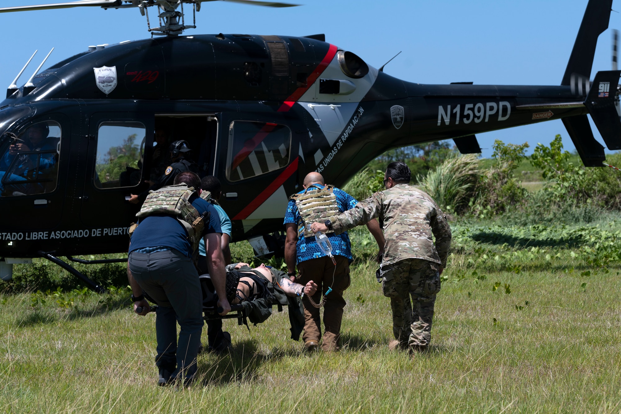 U.S. Air Force Senior Airman Ben Leveillee, a survival, evasion, resistance and escape specialist assigned to the 60th Operations Support Squadron, is transported onto a Puerto Rico Police Department, Fuerzas Unidas de Rápida Acción Bell 429 helicopter during the Advisor Edge exercise at Roosevelt Roads, Ceiba, Puerto Rico, June 8, 2023. Advisor Edge was a multi-unit exercise with the integration of government agencies, where participant units tested air advising skills and strengthened partnerships through unique challenges, allowing burden sharing in combat with partner nations. (U.S. Air National Guard photo by Master Sgt. Rafael D. Rosa)