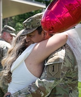 U.S. Army Spc. Adair Estrada, a combat medic with the 2nd Armored Brigade Combat Team, 1st Infantry Division, greets his fiancé after a 9-month deployment to Europe at the Cavalry Parade Field, Fort Riley, Kansas on June 22, 2023. The Dagger Brigade's mission was to train the host country's security forces and enhance interoperability with our NATO Allies and partners by building enduring relationships. (U.S. Army photo by Spc. Ellison Schuman)