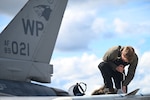 Airman 1st Class Wyatt Martin conducts post-flight maintenance on an F-16 Fighting Falcon during RED FLAG-Alaska 23-2.