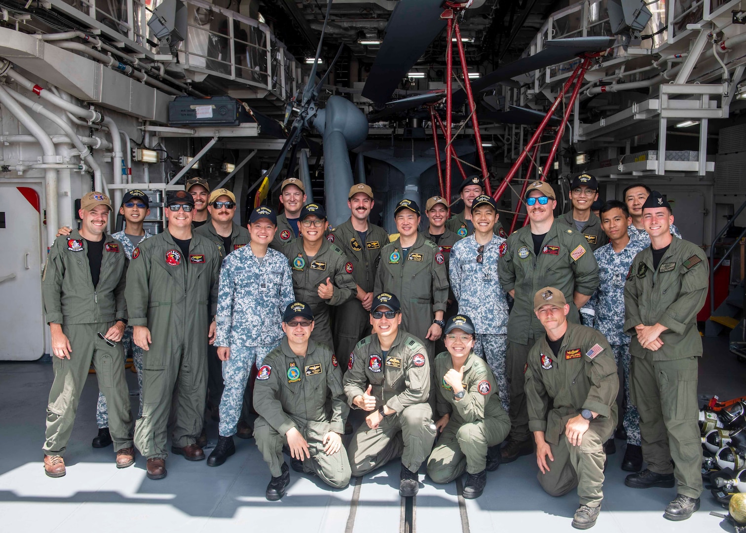 SANTA RITA, Guam, (June 19, 2023) – U.S. and Singaporean Sailors pose for photo in the hangar bay of Independence-variant littoral combat ship USS Manchester (LCS 14), during Exercise Pacific Griffin 2023. Pacific Griffin 2023 is a biennial maritime exercise between the U.S. and Republic of Singapore. Conducted in the waters near Guam, the two navies enhance combined maritime proficiency while strengthening relationships during two weeks of dynamic training evolutions ashore and at sea. Littoral Combat Ships are fast, optimally manned, mission-tailored surface combatants that operate in near-shore and open-ocean environments, winning against 21st-century coastal threats. Manchester, part of Destroyer Squadron 7, is on a rotational deployment operating in the U.S. 7TH Fleet area of operations to enhance interoperability with Allies and partners and serve as a ready-response force in support of a free and open Indo-Pacific region. (U.S. Navy photo by Mass Communication Specialist 2nd Class Christopher Thomas)