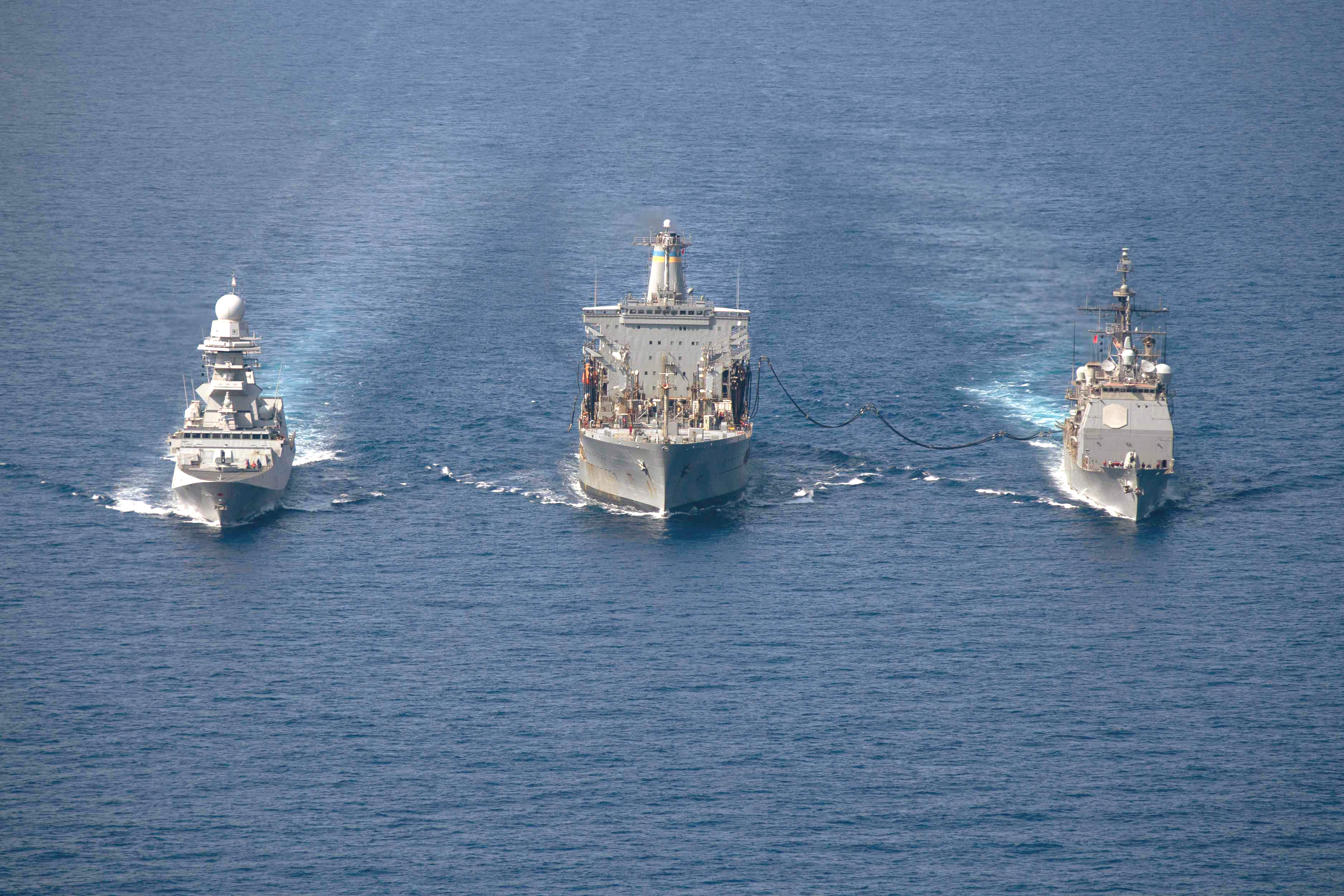 The Italian navy frigate Alpino (F 594), left, and the Ticonderoga-class guided-missile cruiser USS Normandy (CG 60) perform a refueling-at-sea evolution with the fleet replenishment oiler USNS Leroy Grumman (T-AO 195) in the Adriatic Sea.