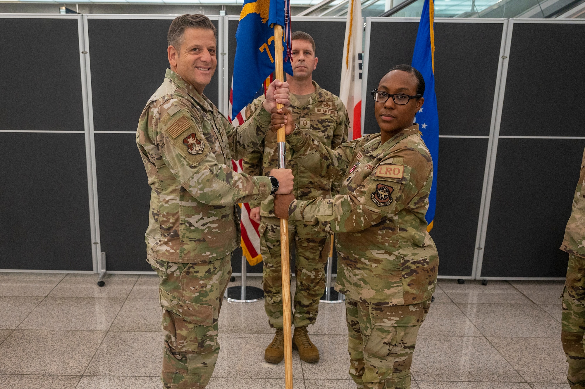 U.S. Air Force Col. Christopher Kiser, left, 515th Air Mobility Operations Group commander, receives the guidon from Lt. Col. Sabrina Winter, 731st Air Mobility Squadron outgoing commander,  at Osan Air Base, Republic of Korea, June 23, 2023. In a change of command ceremony, the guidon symbolizes the transfer of command, the authority and responsibility associated with it.  (U.S. Air Force photo by Senior Airman Aaron Edwards)
