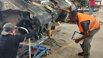 Dwann Jackson, an Army Field Support Battalion-Mannheim quality assurance specialist, observes onsite suspension and track upgrades to an Army Prepositioned Stocks-2 M2 Bradley fighting vehicle at the Coleman APS-2 worksite. (U.S. Army courtesy photo)