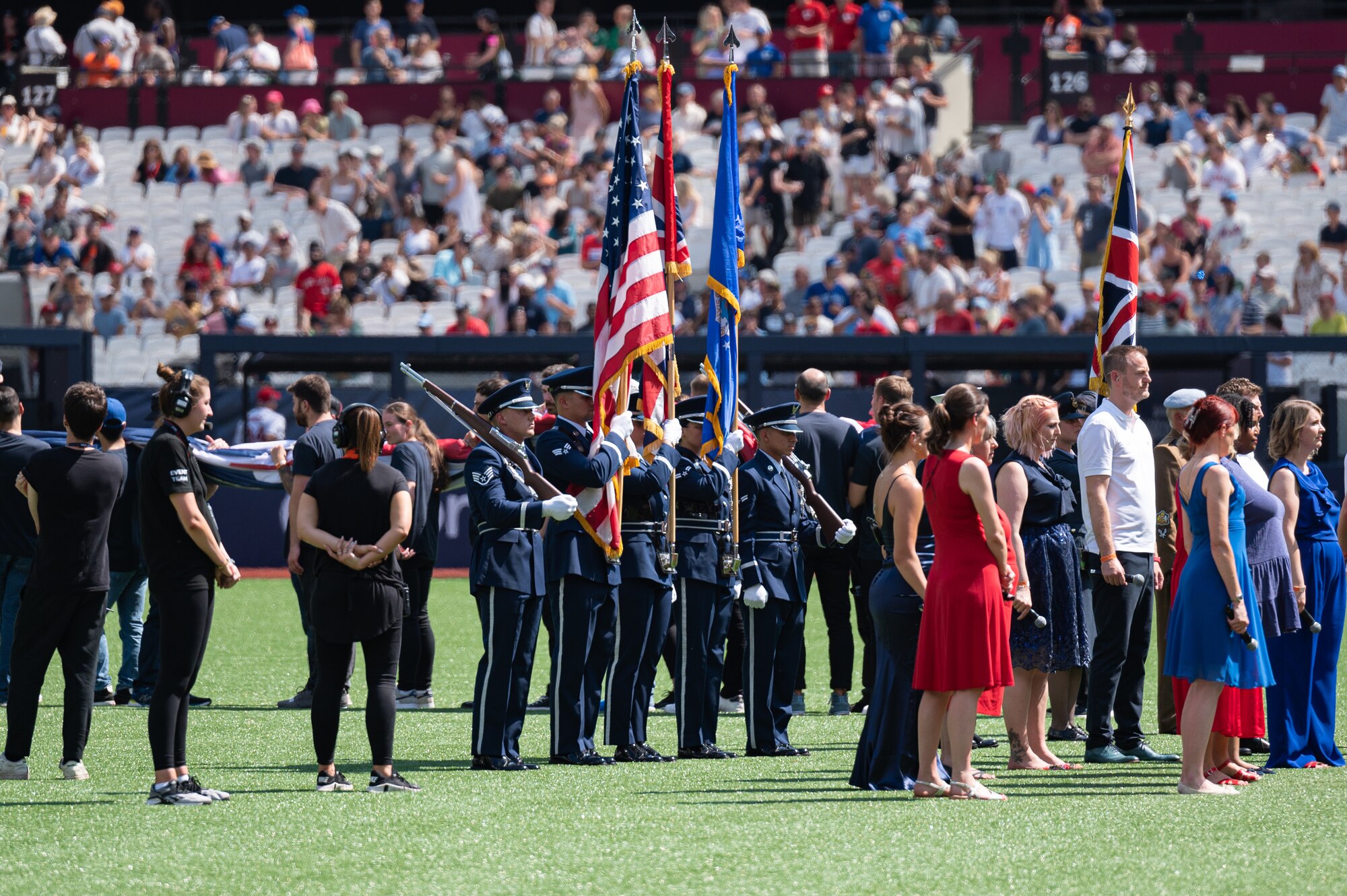 A U.S. Air Force Airmen assigned to the 100th Air Refueling Wing honor guard, present the colors on the field during the pre-game ceremony at London Stadium, England, June 25, 2023.